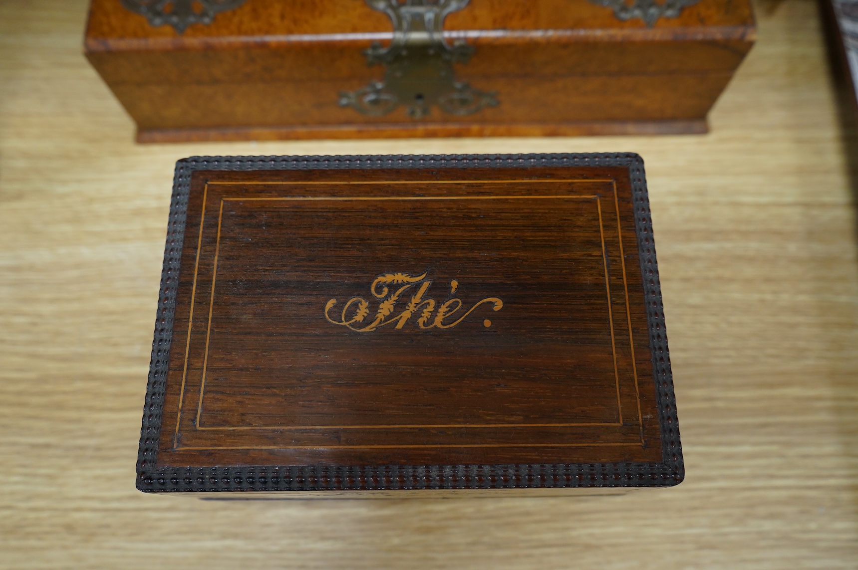 Four boxes to include a burr elm bound example, together with a French inlaid ‘Thé’ caddy with porcelain canisters, largest 32cm wide